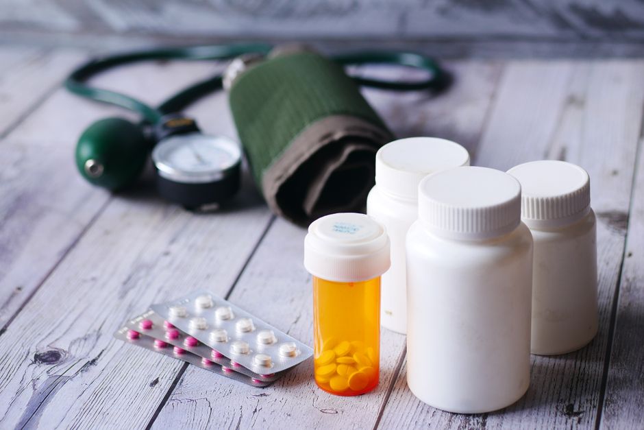 A cup of coffee next to oxycodone pills on a table, illustrating the topic of coffee and medication interaction