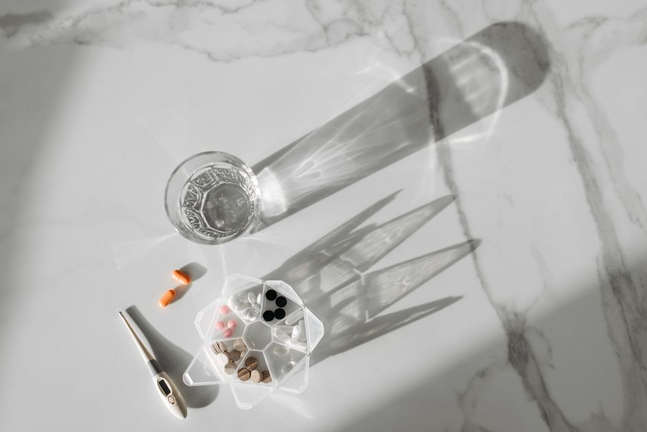 A cup of coffee next to oxycodone pills on a table, representing the interaction between caffeine and opioid medication