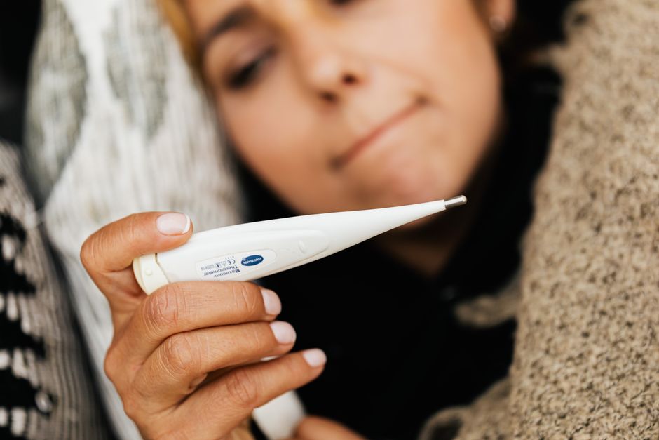 Person feeling ill in bed with symptoms similar to both flu and oxycodone withdrawal