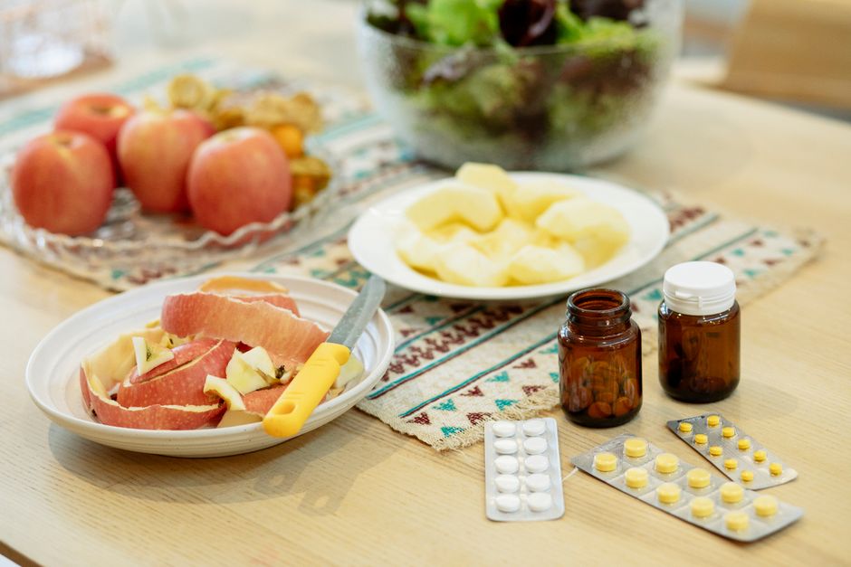 Oxycodone pills next to a small plate of food representing whether to take medication before or after eating