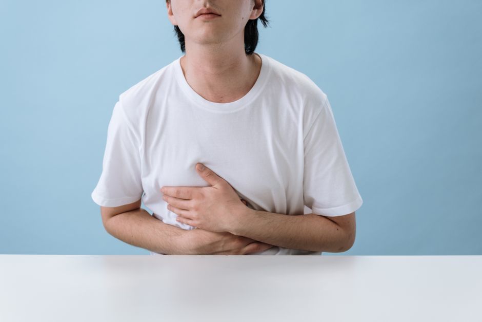 Person holding their abdomen due to discomfort from oxycodone-induced constipation