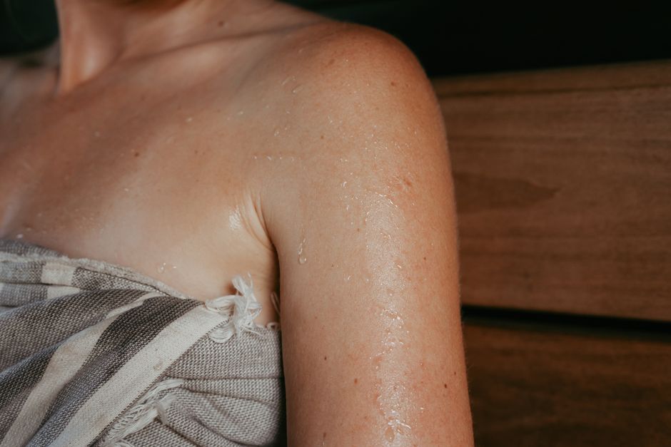 Person wiping sweat from forehead, illustrating oxycodone-related sweating side effect