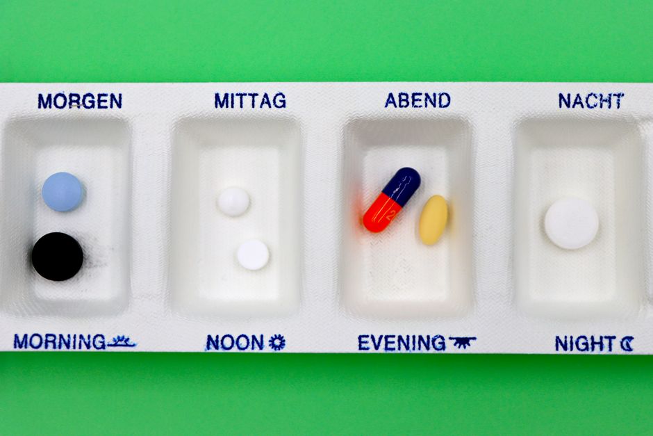 Pill organizer and clock representing a missed oxycodone dose and medication schedule