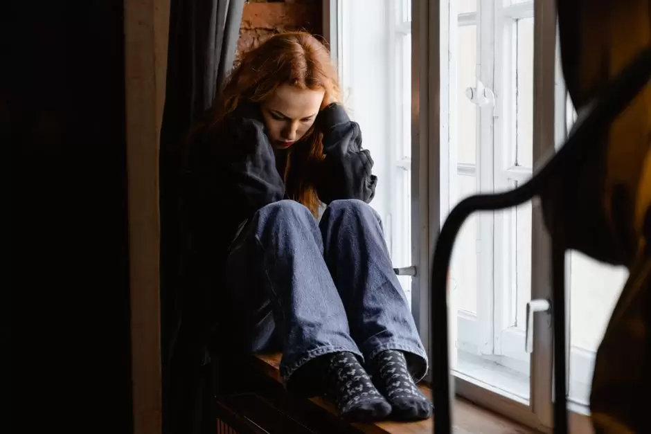 Person sitting on a bed looking anxious and overwhelmed during oxycodone withdrawal