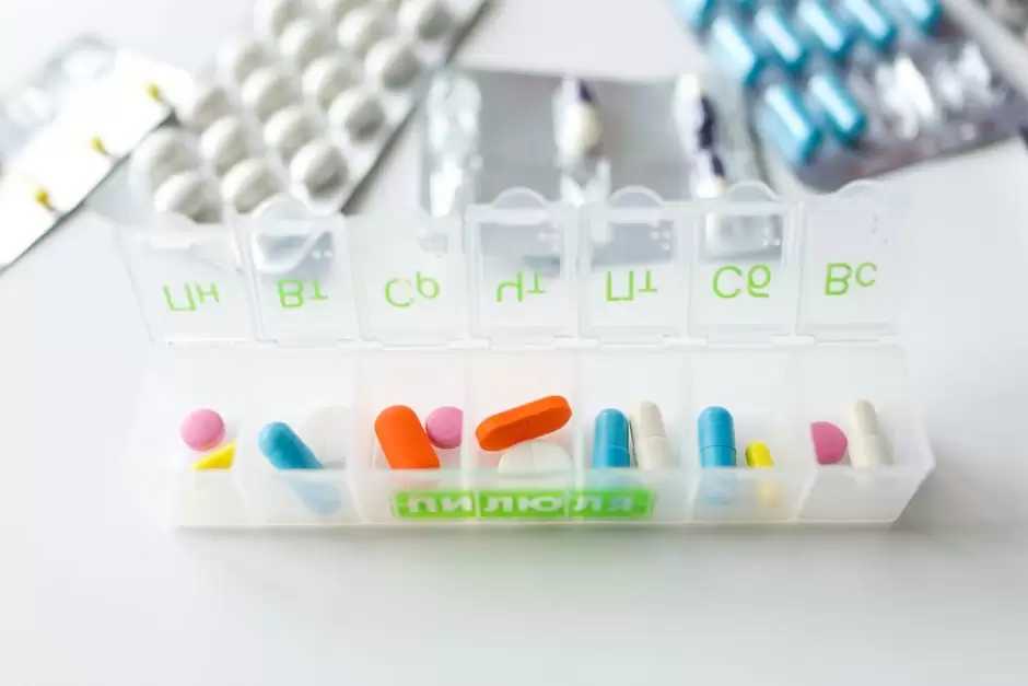 Clock and pill organizer representing the best time to take oxycodone for pain relief