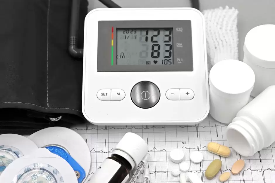 Person checking blood pressure with a monitor next to oxycodone pain medication